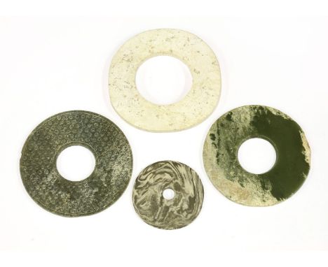 A collection of four Chinese jade bi discs,comprising:a white example, possibly of Liangzhu culture (3400-2250 BC), plain, 16