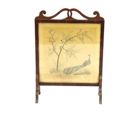 An Edwardian mahogany firescreen, with a shaped top and a silk floral inset panel, 79cm high, 56cm wide, 22cm deep.