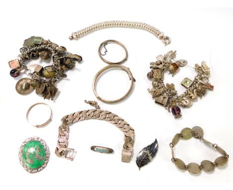 A group of silver and other jewellery, comprising silver and green enamel oval brooch, two silver charm bracelets, bangles, b