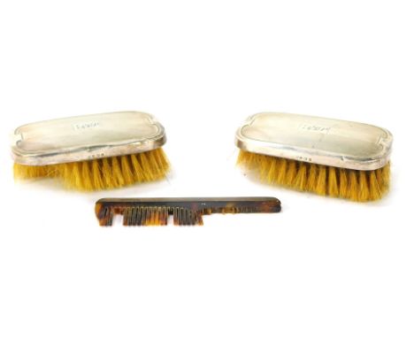 An Elizabeth II travel dressing table set, comprising two silver backed brushes with engine turned design and central crest s