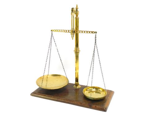 A 20thC table top brass scale, on mahogany base with brass supports lacking weights, 62cm high, 52cm wide, 30cm deep.