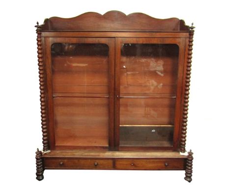 A Victorian rosewood bookcase, with a shaped tray top, on fluted and moulded column supports, with two large two sectioned as