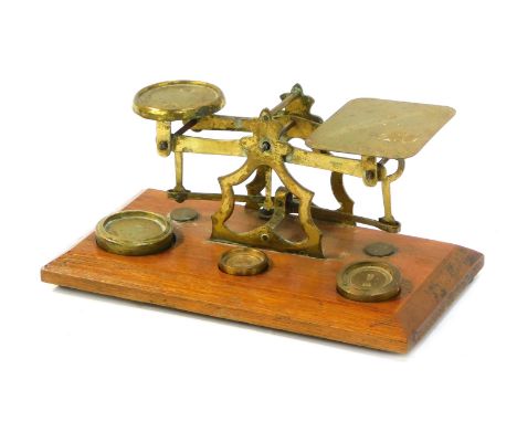 A 20thC brass Criterion table postal scale on oak base, with removable weights.