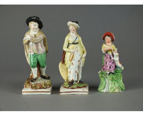 A group of three Staffordshire figures, early 19th century, 13cm high, a female figure feeding a lamb, 13.5cm high, a male fi