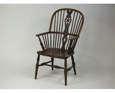An elm seat wheel and stick back Windsor chair, 19th century, with ring turned legs joined by an H-stretcher, split and old w