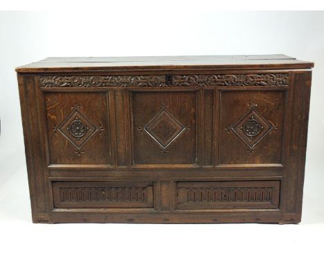 A joined oak mule chest, 17th century the rectangular two plank top enclosing a candle box above a foliate carved frieze and 