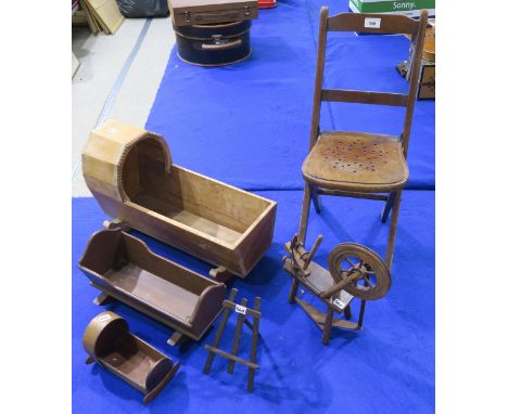 A collection of dolls furniture, comprising three cribs of varying size, a spinning wheel, folding chair etc., together with 