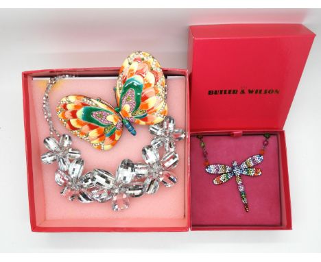 Two Butler &amp; Wilson necklaces a rainbow dragonfly, and a crystal flower, together with a butterfly mirror compact Conditi