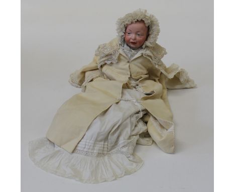 An early 20th century Kammer and Reinhardt bisque head baby doll, mould number 36. Painted facial features, lace trimmed Chri