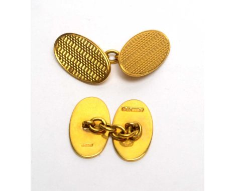 A pair of 9ct yellow gold cufflinks, in oval form with engine turned design, 8.9g gross. 