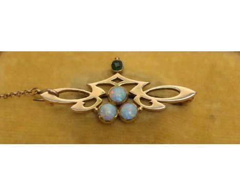 An Edwardian 15ct yellow gold brooch set with opal cabochons and emerald, by EPE, 3.9cms wide, 3.7g gross. 