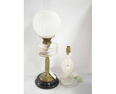 A Victorian brass oil lamp, with clear glass reservoir and funnel, mottled glass shade, raised over a stepped circular base, 