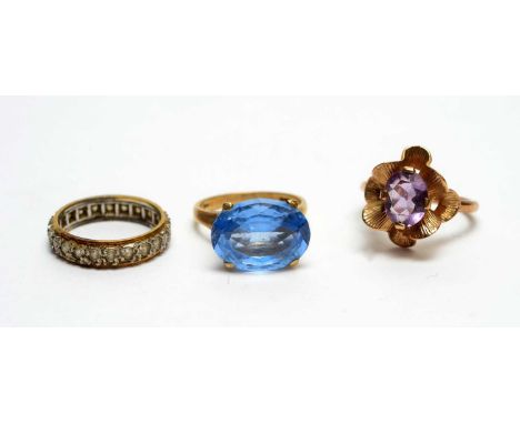 An amethyst and 9ct yellow gold ring, wavy design; a light blue topaz ring, in modern 9ct yellow gold mount and shank; an a w