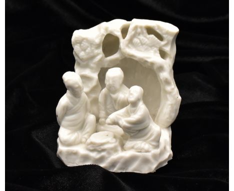 A CHINESE BLANC-DE-CHINE DEHUA GROTTO FIGURE GROUP, QING DYNASTY, KANGXI PERIOD, 1662 – 1722Modelled with three scholars seat