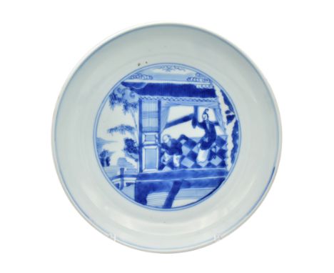 A CHINESE BLUE AND WHITE PORCELAIN SAUCER DISHPainted to the centre with a lady and small boy on a garden terrace, observing 