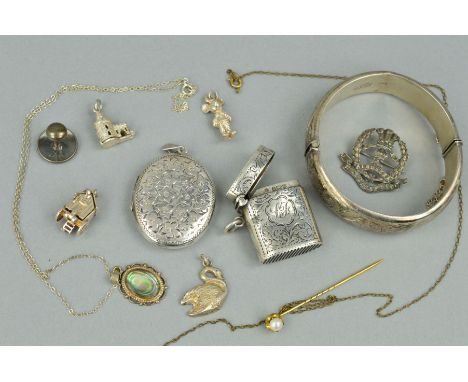 A SELECTION OF MAINLY SILVER AND WHITE METAL JEWELLERY to include a hinged bangle, an oval locket, three loose charms, two pe