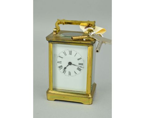 AN EARLY 20TH CENTURY BRASS CASED CARRIAGE CLOCK, white enamel dial, Roman numerals, fire glazed panels, height to top of han