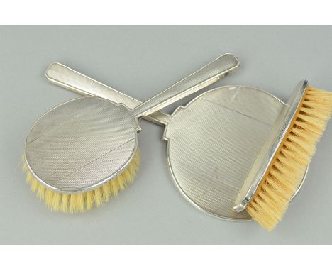 A THREE PIECE SILVER BACKED DRESSING TABLE SET, comprising hand mirror (loose) and two brushes, engine turned decoration, Bir