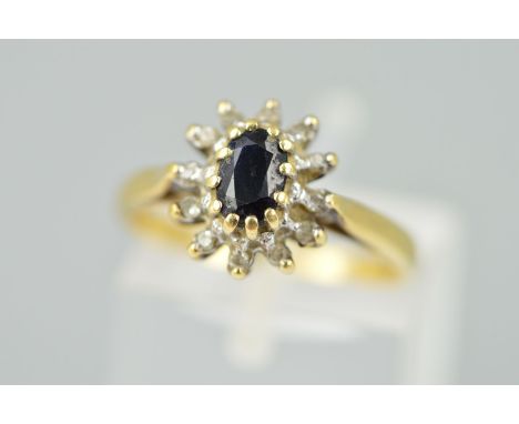 A 9CT GOLD SAPPHIRE AND DIAMOND CLUSTER RING, designed as a central oval sapphire within a single cut diamond surround, with 