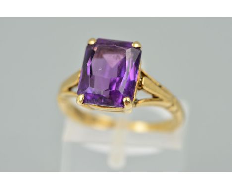 A 9CT GOLD AMETHYST RING, the rectangular amethyst within a four claw setting to the branched shoulders, hallmarked Birmingha