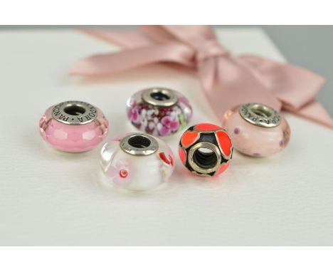 FIVE PANDORA CHARMS AND A MAKERS BOX to include two glass charms with floral detail, one glass charm with faceted finish, one