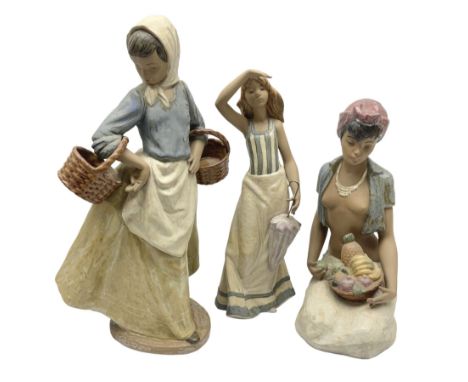 Nao Gres figure of a girl carrying baskets, together with two others one of a woman with a fruit basket and another holding a