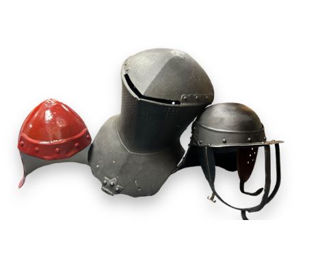 Three Reproduction Medieval Helmets. One metal pot helmet painted black. One frog mouth helmet made from fibre glass. One red