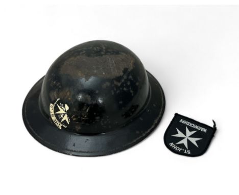 Second World War Civil Defence Steel Brodie helmet with black lacquer and The St. John Warwickshire emblem to front (deterior