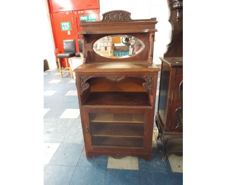 A Late Victorian Mahogany Music Cabinet with Oval Mirror to Galleried Shelf, Centre Open Section and Glazed Shelved Cupboard.