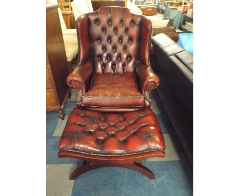 A Button Upholstered Red Leather Wing Arm Chair with Matching X Frame Foot Stool 