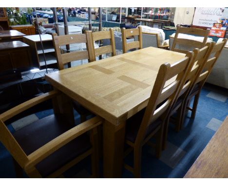 A Heavy Light Oak Extending Dining Table and Eight Ladder Back Chairs to Include Two Carvers 