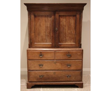 A 19th century Welsh oak linen press / livery cupboard, the moulded cornice over a pair of panelled cupboard doors opening to