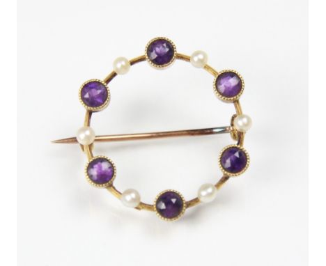 An early 20th century amethyst and seed pearl brooch, the circular openwork brooch with round cut amethyst set within yellow 