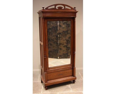 A French pitch pine single wardrobe, late 19th/early 20th century, the arched openwork pediment over ring turned pillars flan