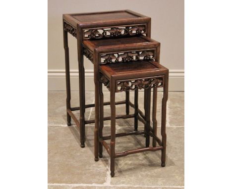 A nest of three Chinese rosewood tables, 20th century, of rectangular form, with a carved vinery openwork frieze, upon slende
