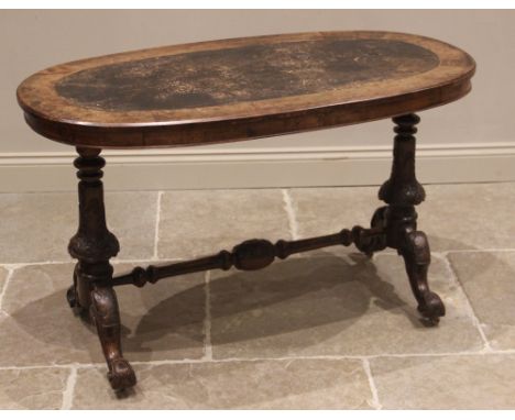 A Victorian figured walnut oval centre/occasional table, the moulded top inset with a leather skiver, upon a pair of leaf car