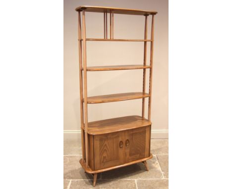 An Ercol honey elm and beech Windsor giraffe open bookcase, mid to late 20th century, formed with four oval shelves and a pai