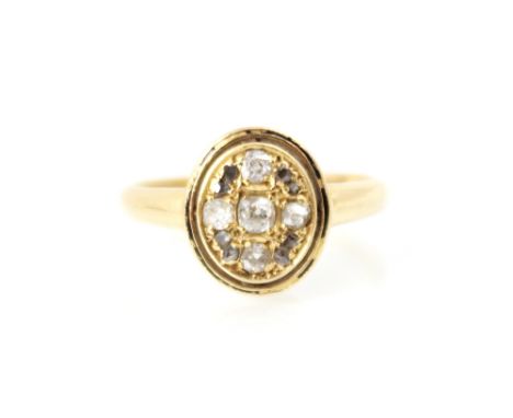 An early 20th century 18ct yellow gold diamond ring, the central oval head set with old cuts and rose cut diamonds, with enam