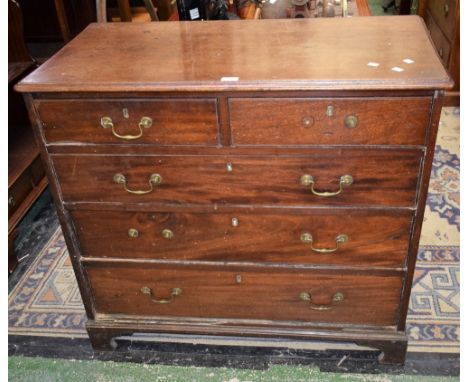 A George III oak and mahogany chest of two short drawers over three long, brass swing handles, bracket feet.