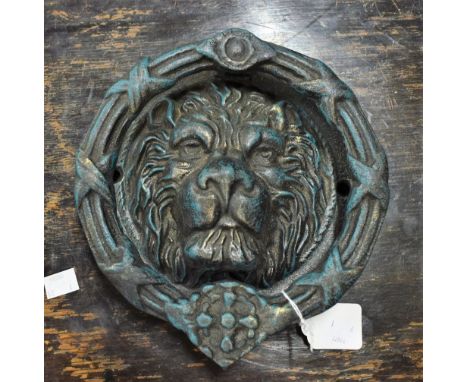 A reproduction cast metal lion head door knocker