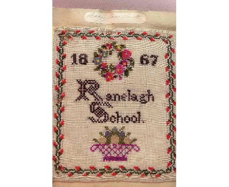 A Victorian scrapbook for Ranelagh School dated 1867 and containing samplers, doll's or miniature clothes and embroidery, com