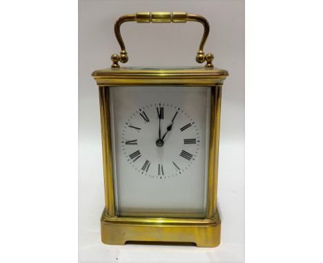 A brass cased carriage timepiece with 2.5in white enamel dial with black Roman Numerals, the case stamped Fabrique de Paris, 