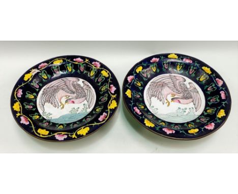A pair of Cantonese enamel on copper pedestal dishes, the well painted with a bird over water, the rim foliate scroll decorat
