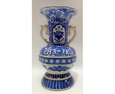 A Chinese blue and white underglaze Ming style vase, the lobed flared neck applied with elephant handles over the ovoid body 