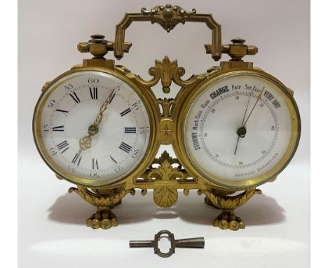 A gilt spelter cased double drum head clock barometer, with white enamel three inch dials, the case with swing handle and app