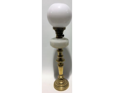 A brass oil lamp with white opaque glass reservoir and ovoid white glass shade, height 58cm