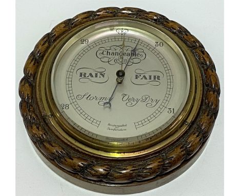 An aneroid barometer within carved oak rope twist case, the 4.5 inch silvered dial signed 'Short &amp; Mason, London'. 