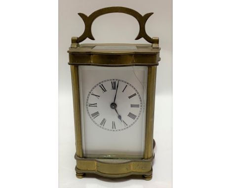 French brass carriage timepiece, the 2in enamel dial with black Roman Numerals, within a lobed case and raised on four turned