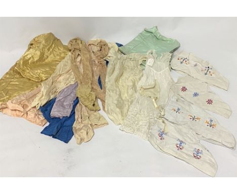 A bag of textiles, including various pairs of silk stockings, lace and silk baby's dresses etc.