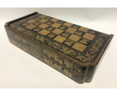 A 19th Century Chinese export black lacquer and gilt decorated hinged games box, the lid and base decorated with a chequerboa